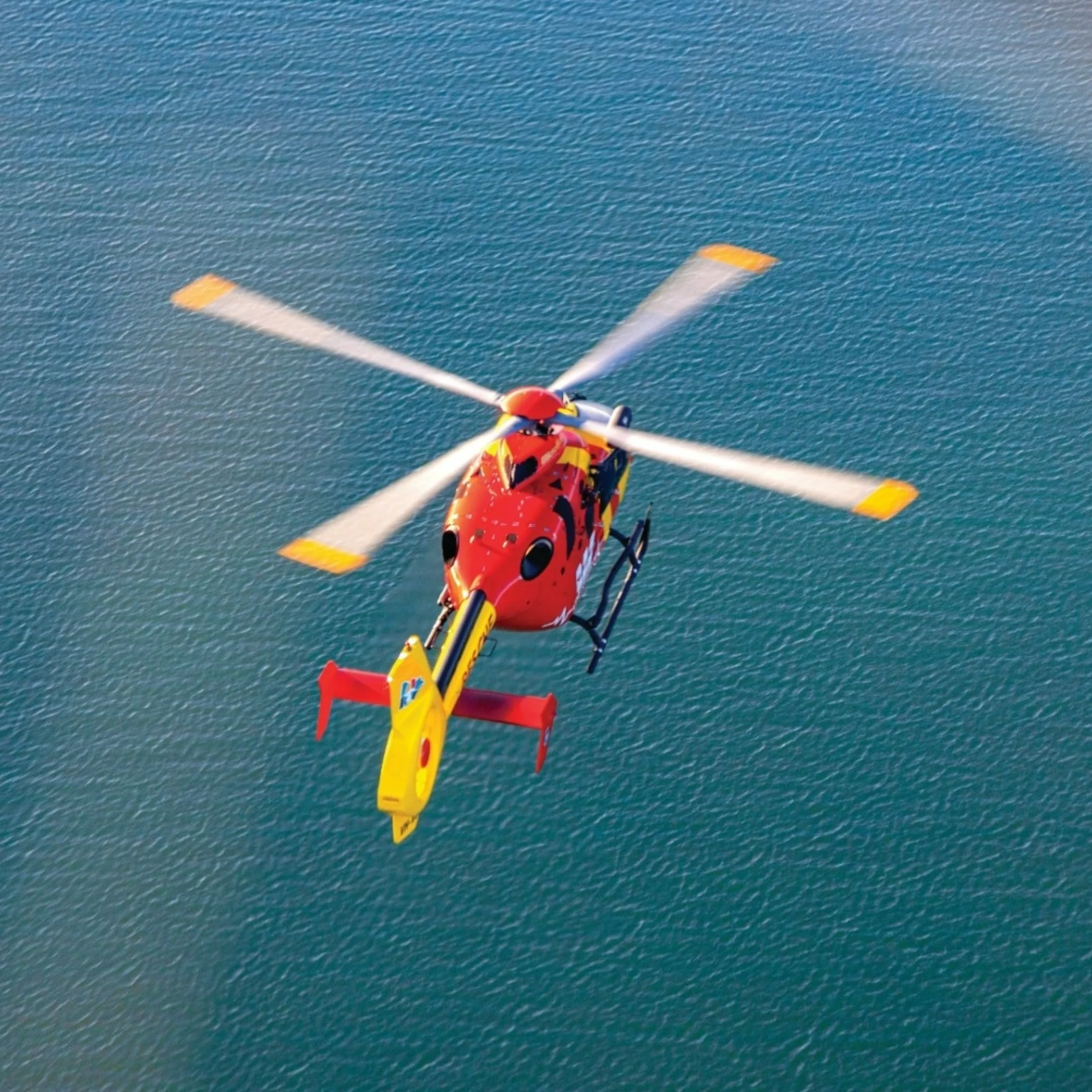 helicopter flying over ocean water