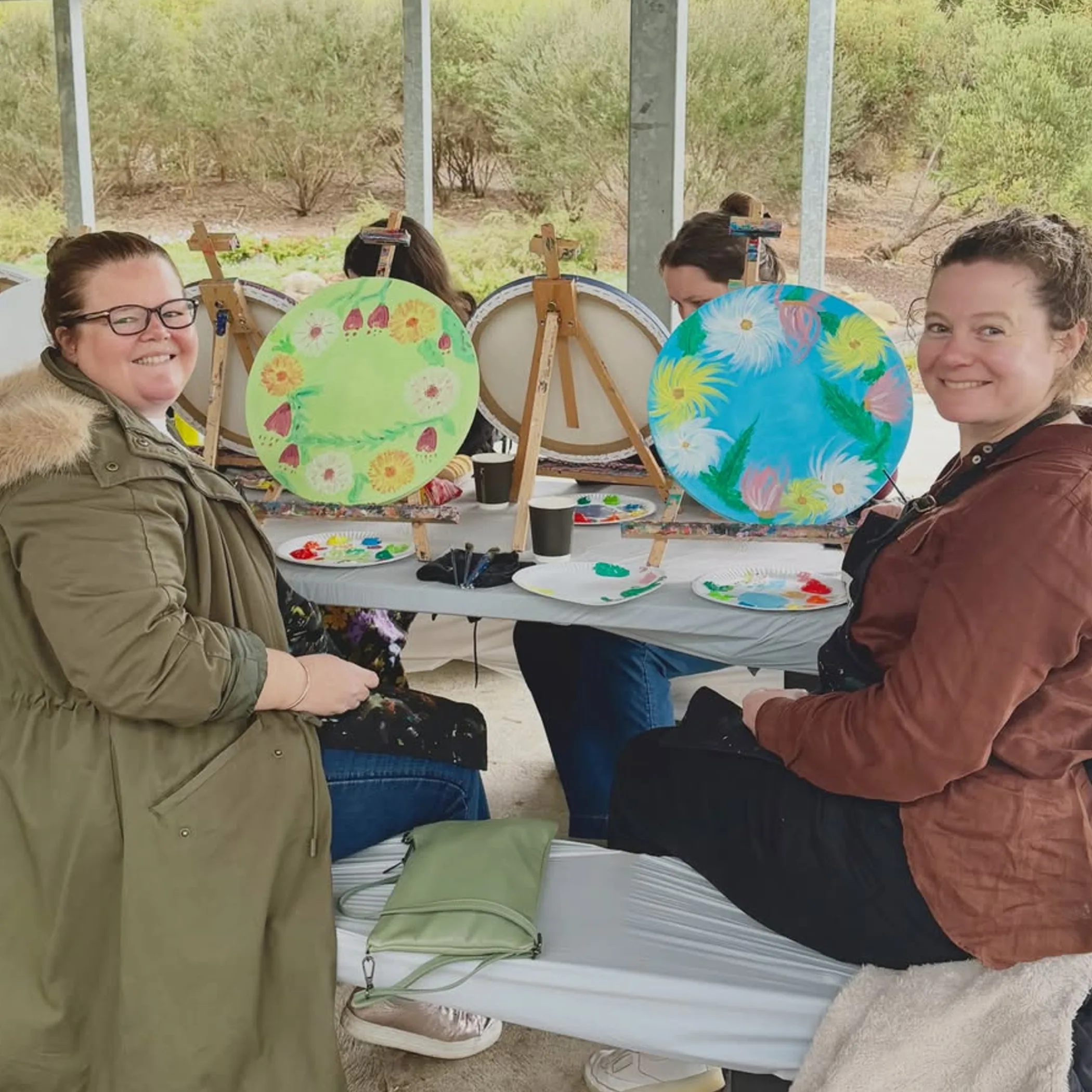 people painting botanical art in garden